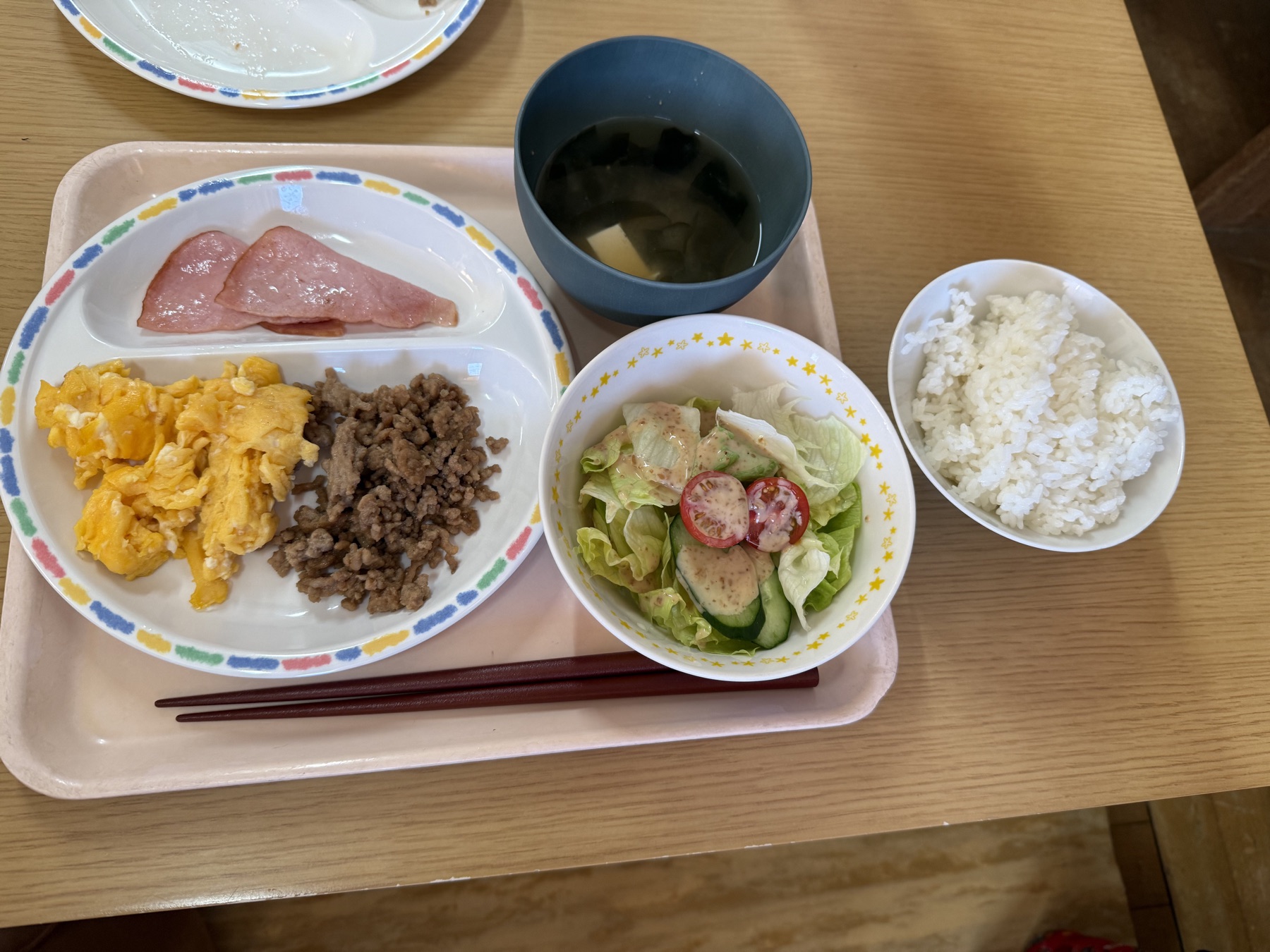 ごはんやみそ汁、卵料理、サラダなどが並ぶ朝食メニュー