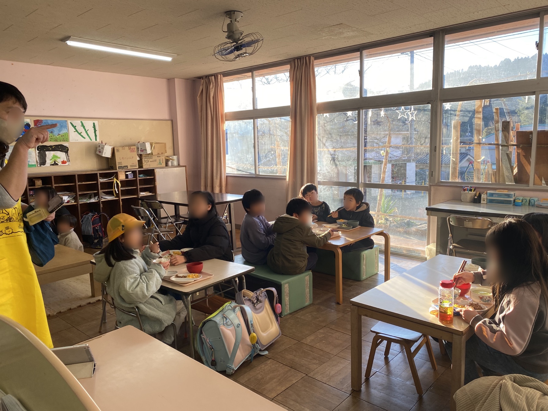 朝の光が入る部屋で、子どもたちが朝ごはんを囲む様子