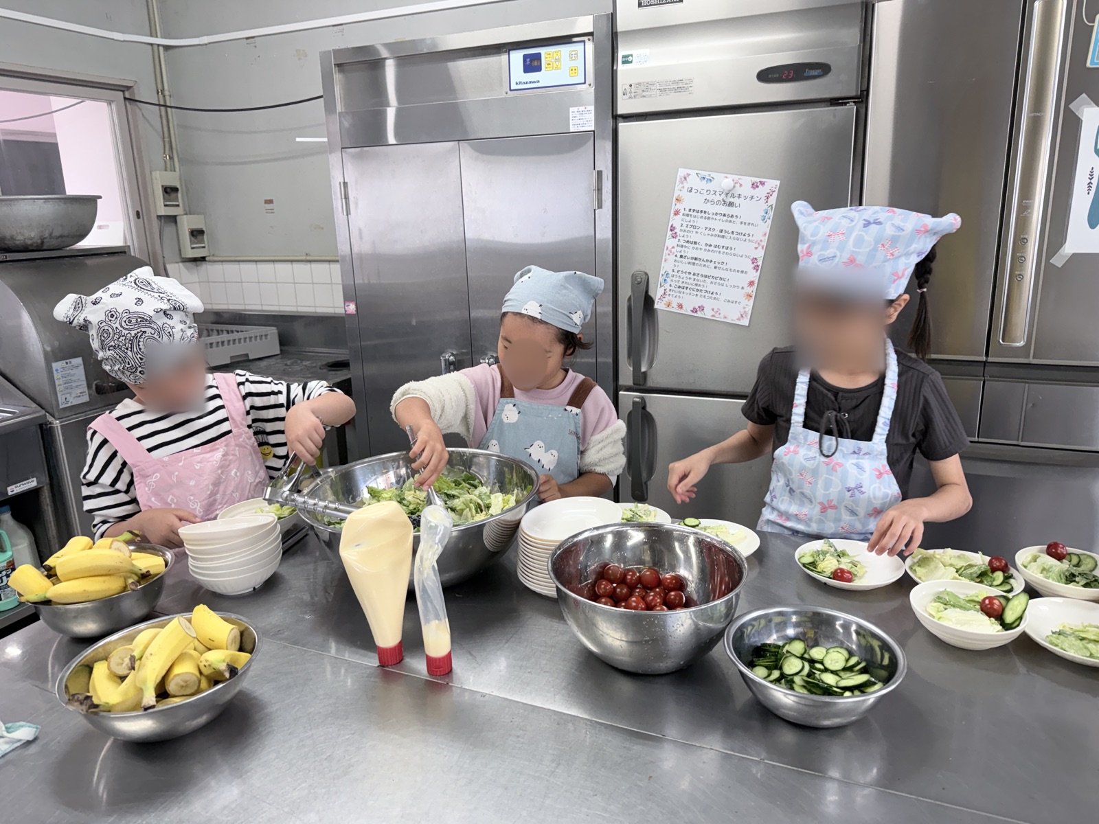 子どもたちが一緒にサラダを盛りつける様子